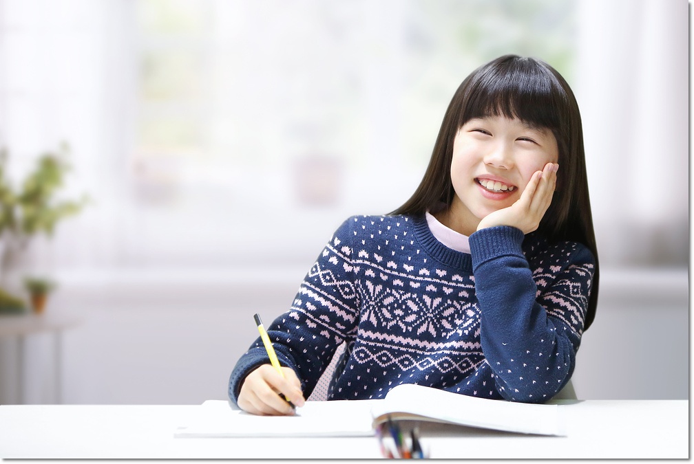 책상에서 필기도구를 들고 있는 학생 · 학습코칭 참고 사진