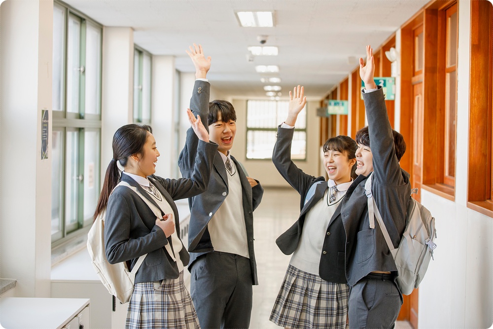교실에서 책을 들고 이야기하는 모습 · 학년·학교생활 참고 사진